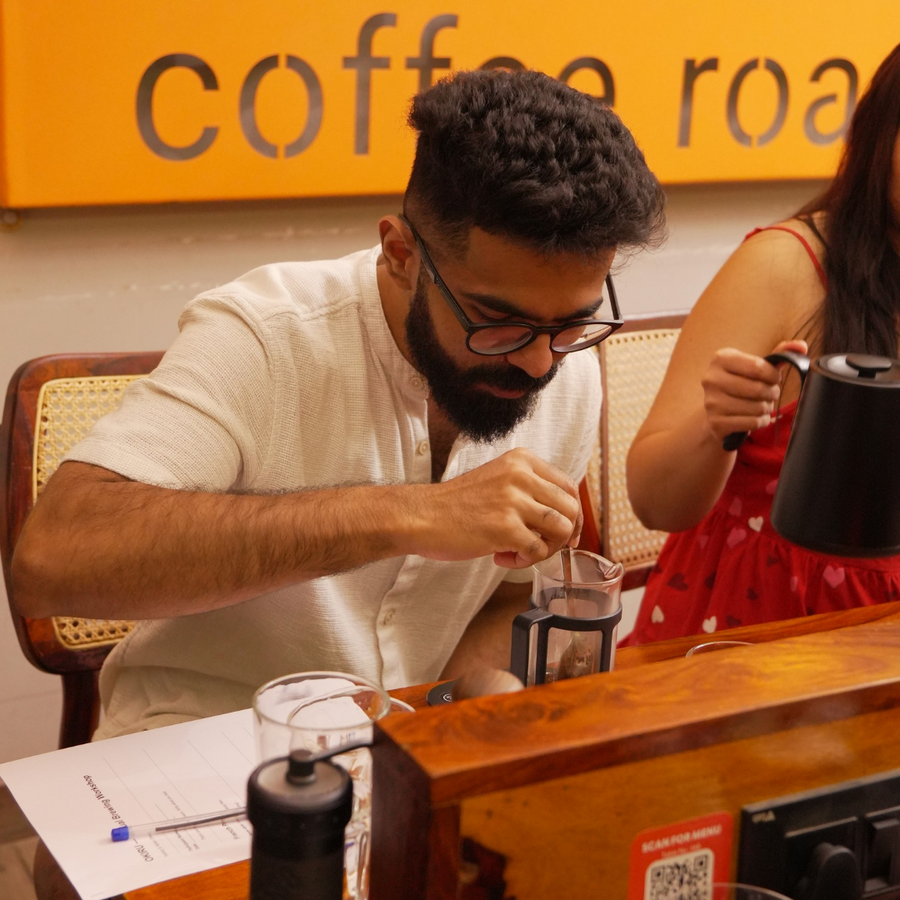 Man making a coffee at a coffee shop with french press