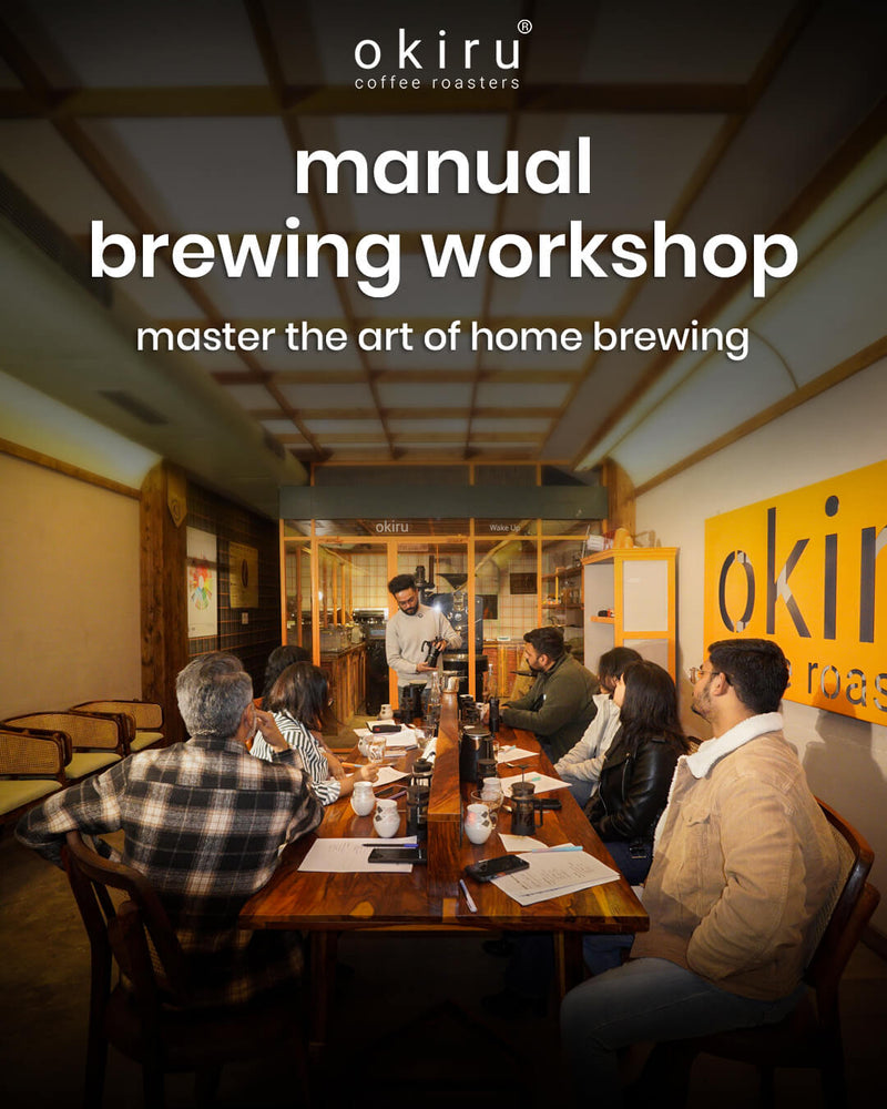 Group of people at a table with okiru coffee roasters branding, participating in a manual brewing workshop.