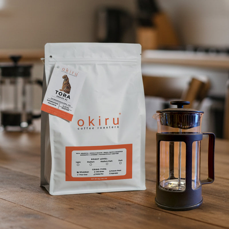 okiru coffee roasters TORA package on a wooden table with a French press in the background