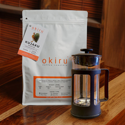 okiru coffee roasters KUJAKU package with a French press on a wooden surface
