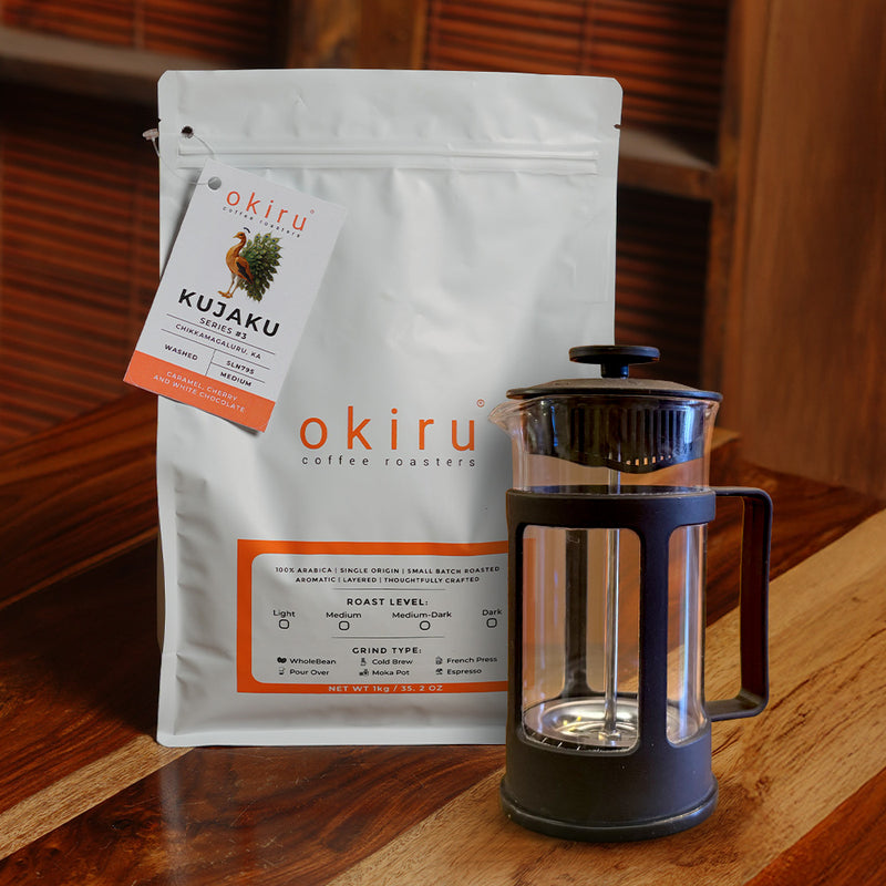 okiru coffee roasters KUJAKU package with a French press on a wooden surface