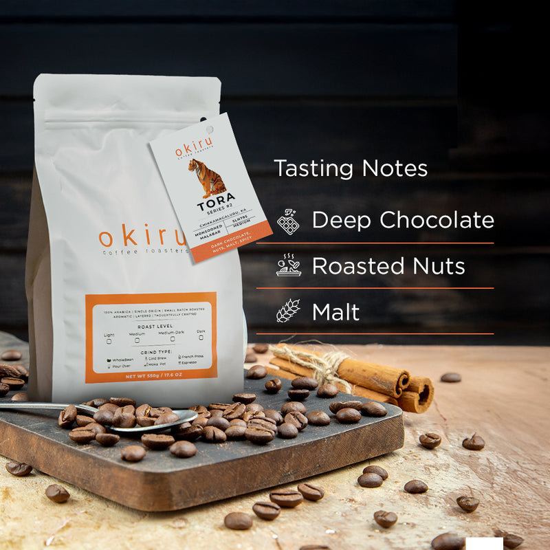 Tora coffee bag with tasting notes on a wooden surface with coffee beans and cinnamon sticks.